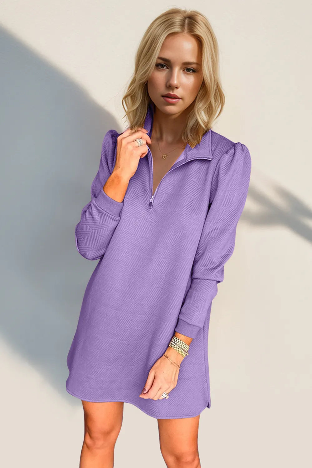 Woman wearing a purple dress against a neutral background