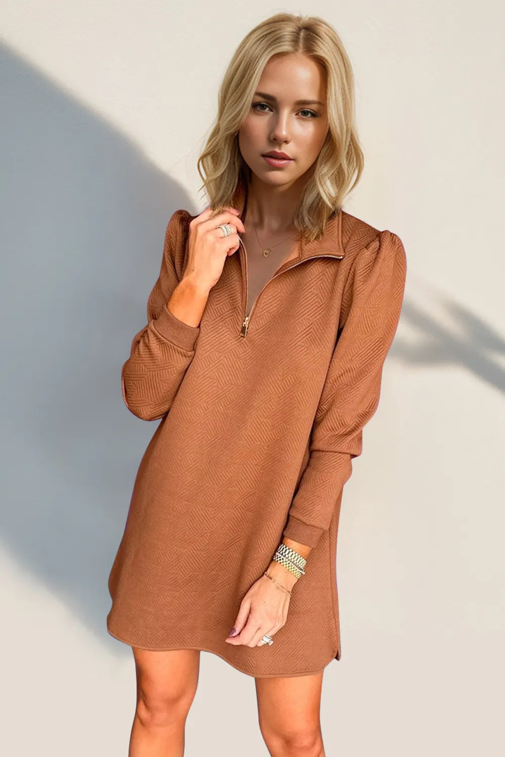 Woman wearing a brown dress against a plain background