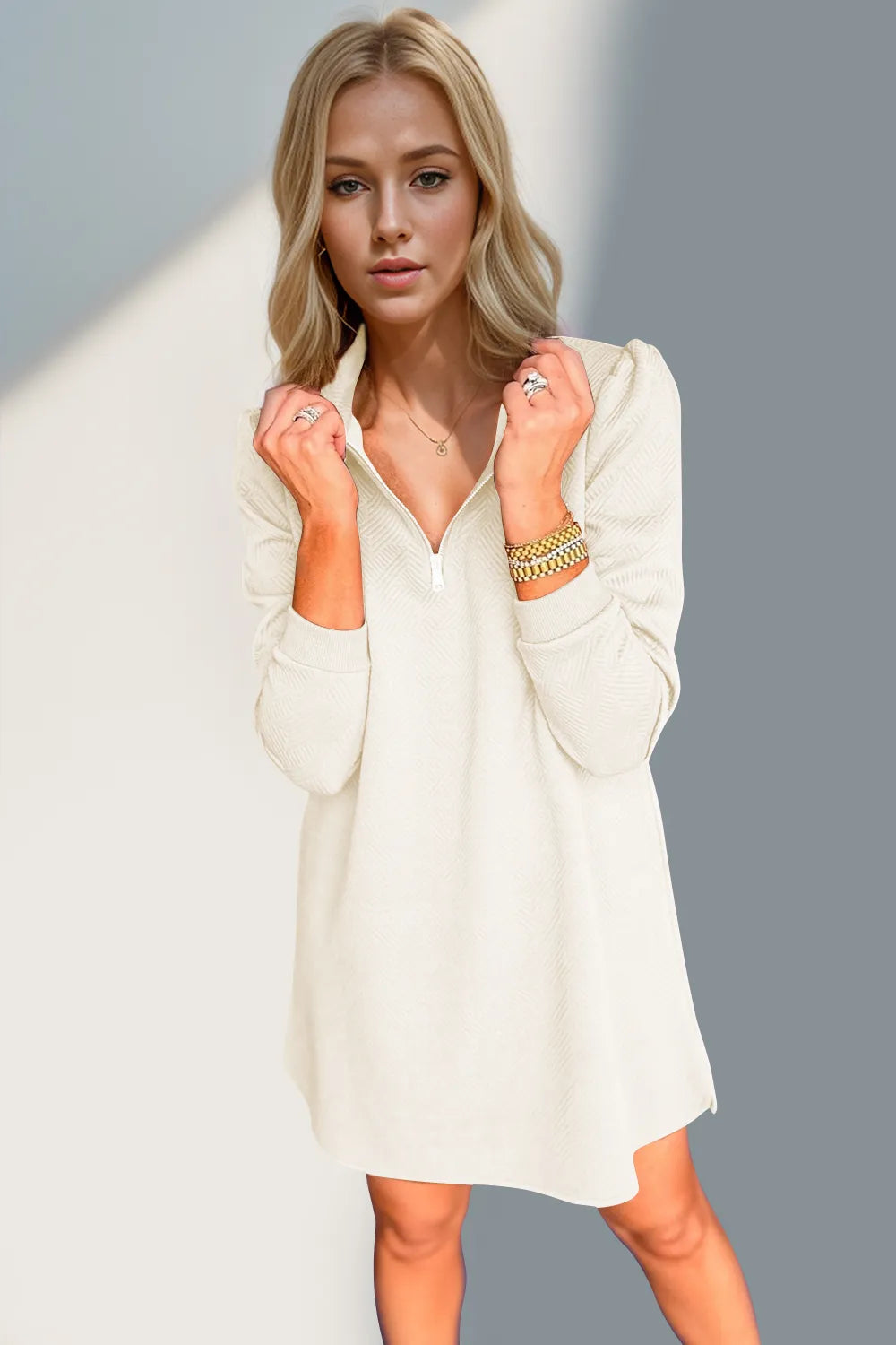 Woman wearing a white dress with long sleeves against a gray background