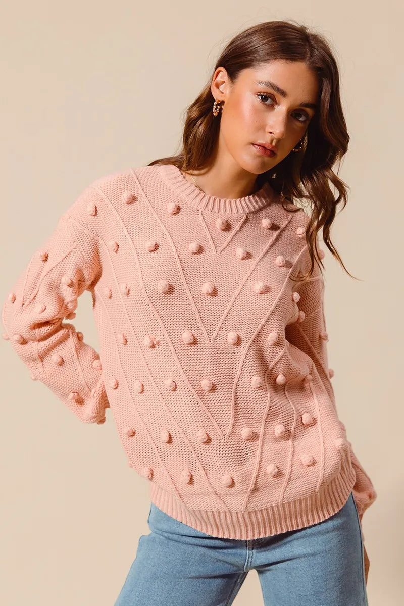 Woman wearing a pink textured sweater against a beige background