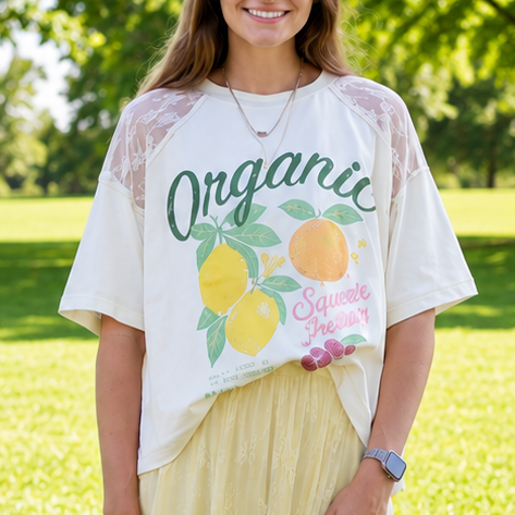 Woman wearing a white t-shirt with a graphic design outdoors on a sunny day