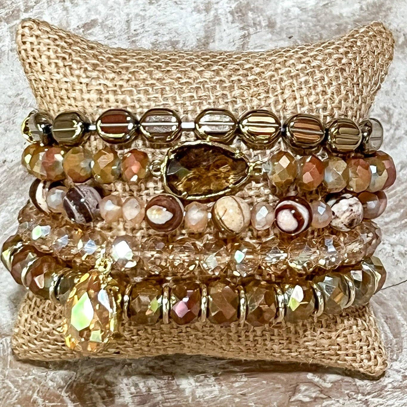 Stack of beaded bracelets on a textured surface