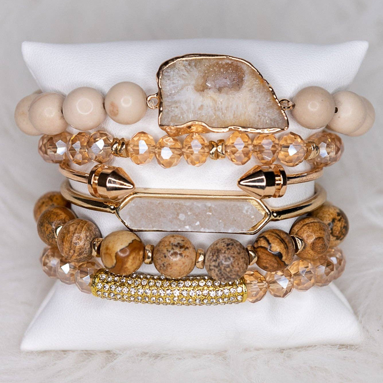 Set of beaded bracelets with gold accents on a white stone surface
