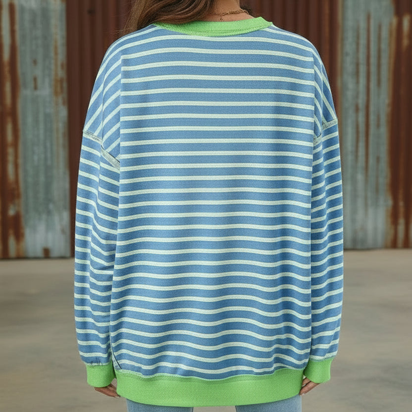 Person wearing a blue and green striped sweater with a white background