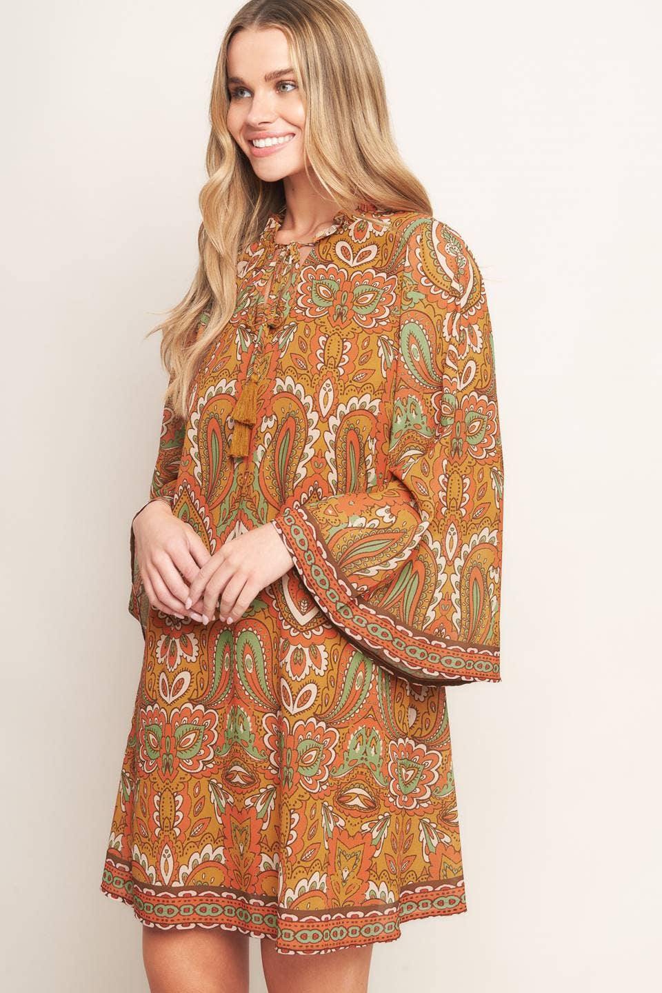 Woman wearing a patterned dress on a plain background