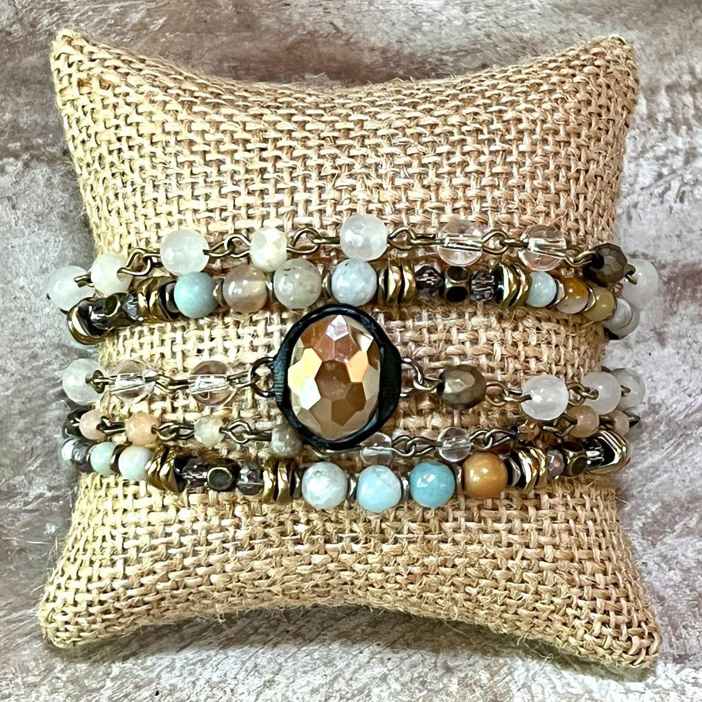 Set of beaded bracelets on a burlap pillow with a textured surface background