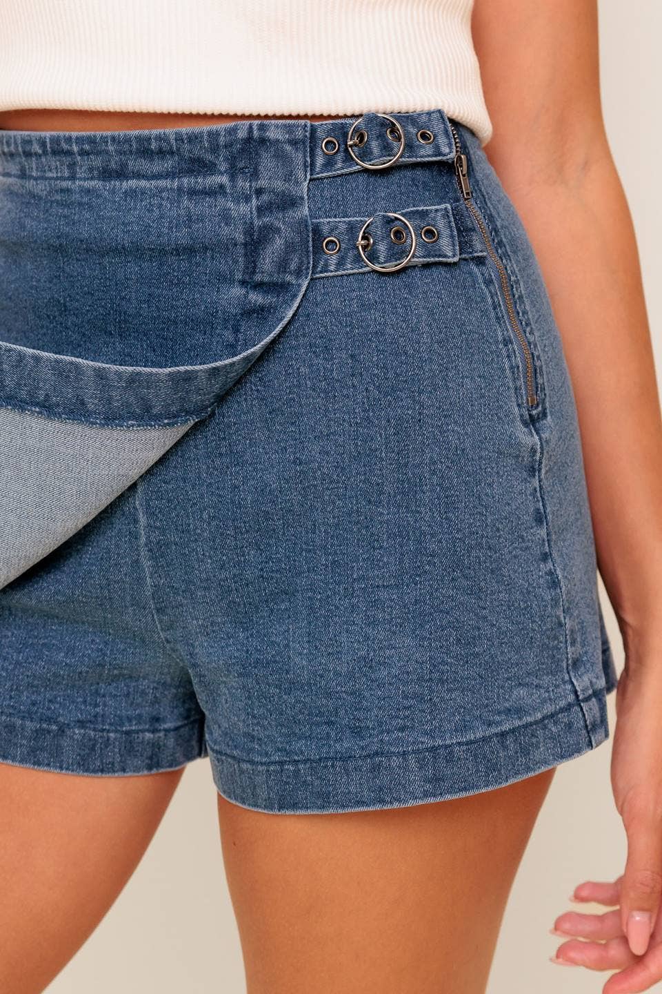 Blue denim shorts with belt loops on a neutral background