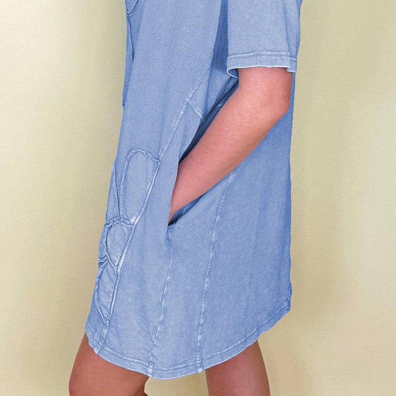 Woman wearing a light blue dress against a beige background