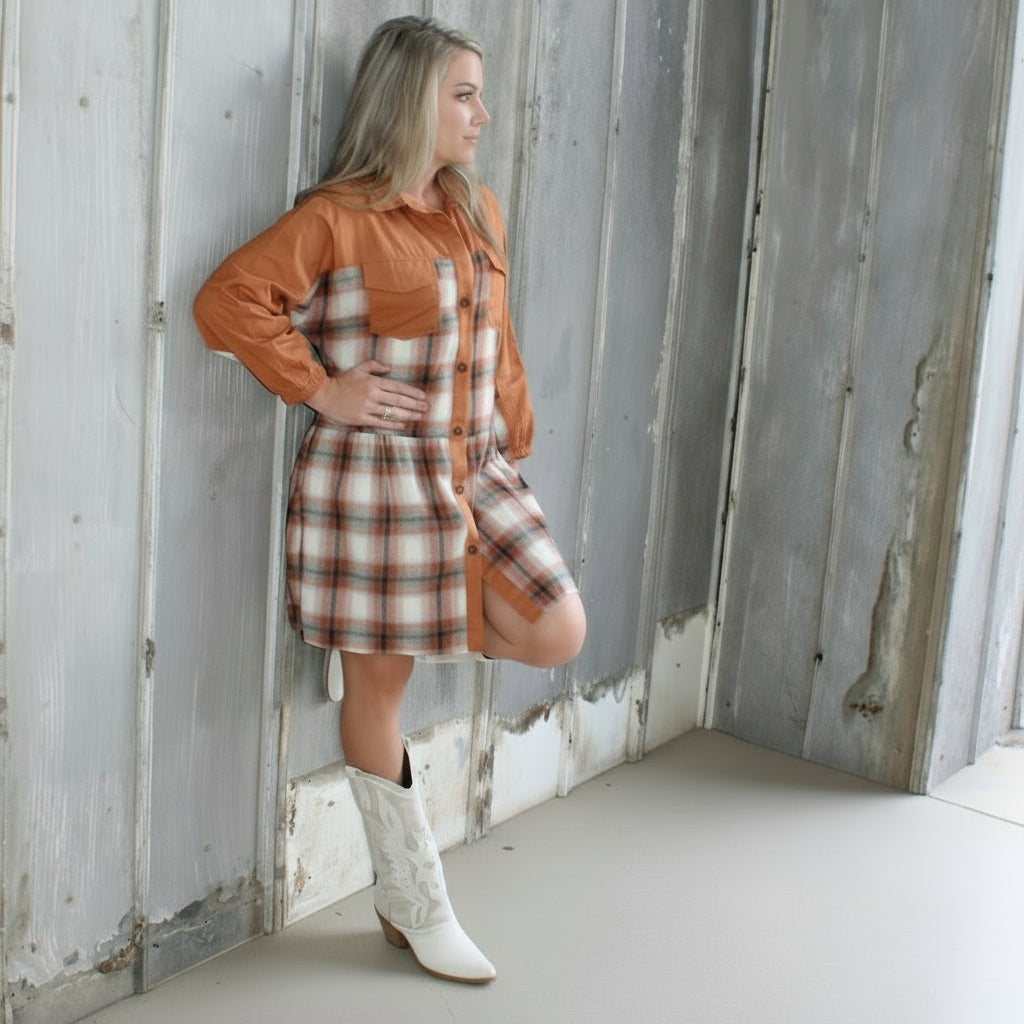 Person lying on a wooden deck with a plaid blanket
